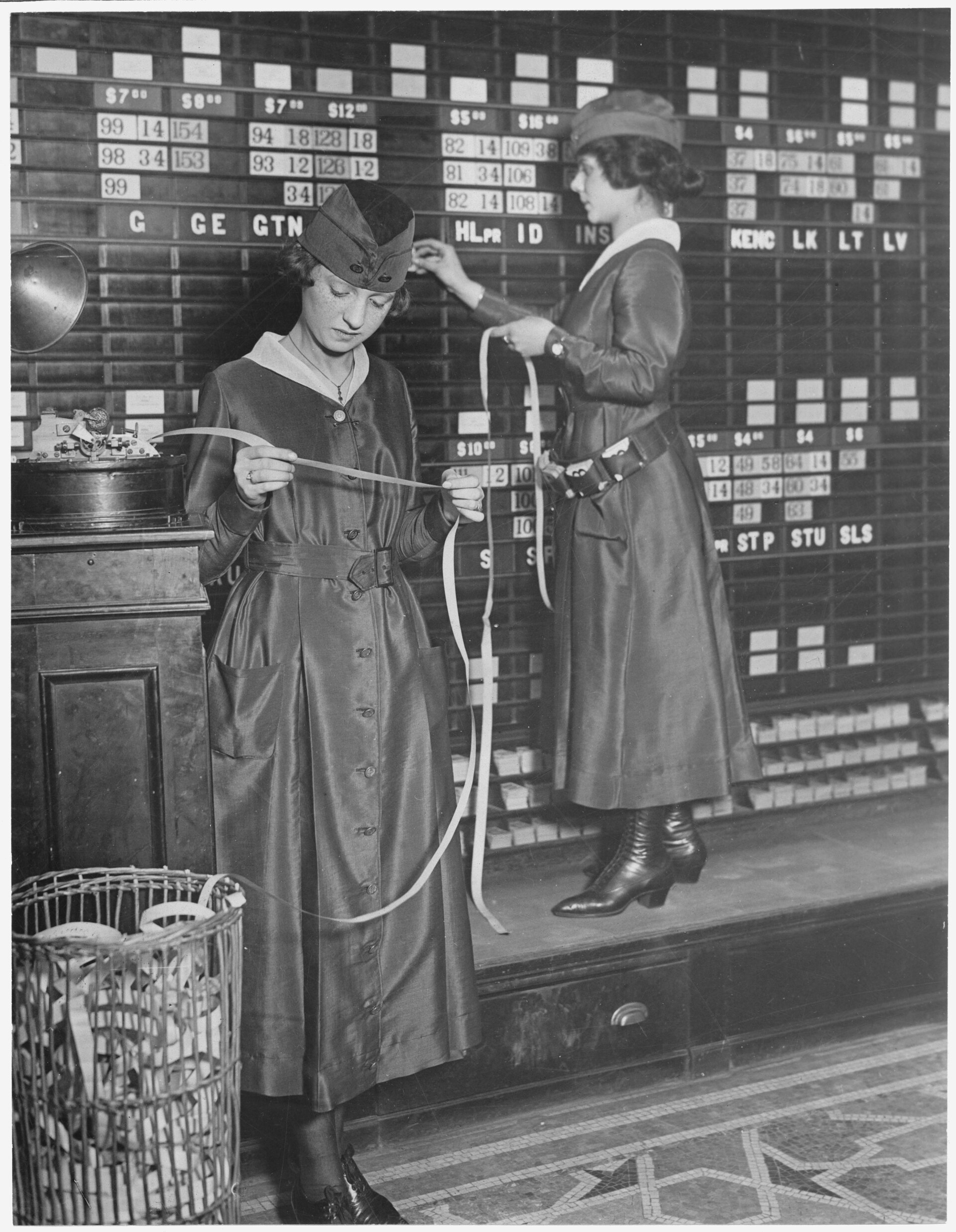 Women operating stock boards and ticker equipment at the Waldorf-Astoria.