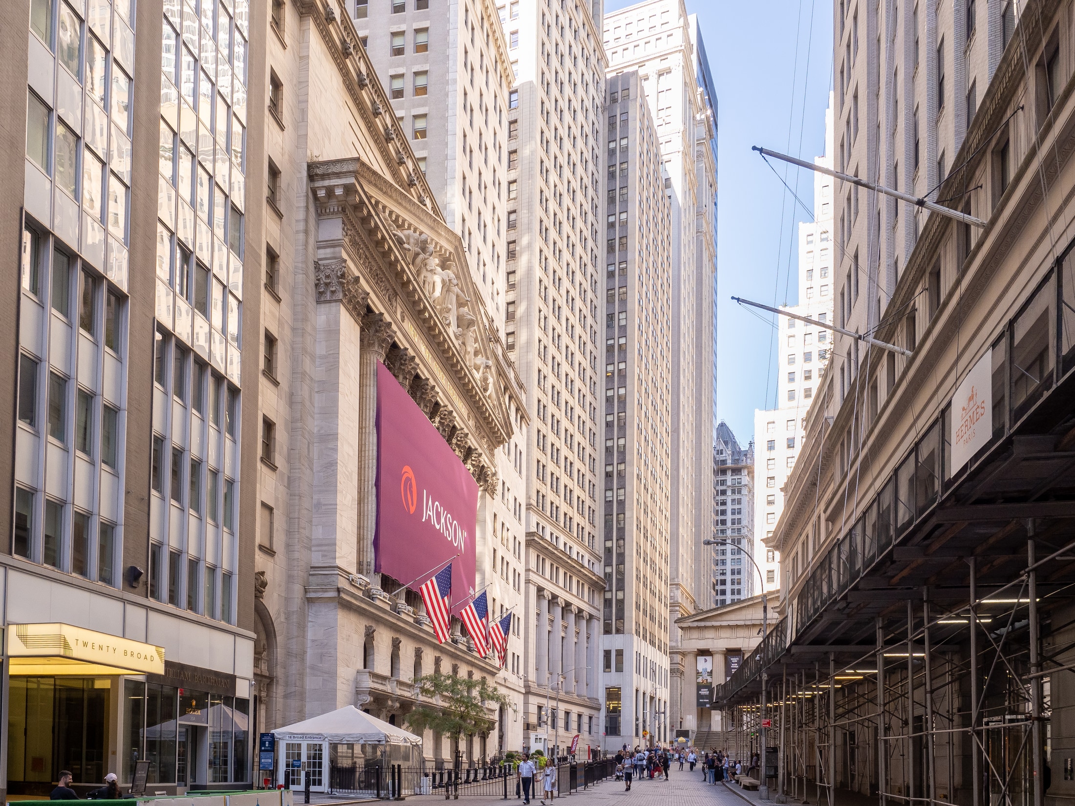 The New York Stock Exchange and Broad Street, with tall buildings, flags, and pedestrians, photographed in September 2021.